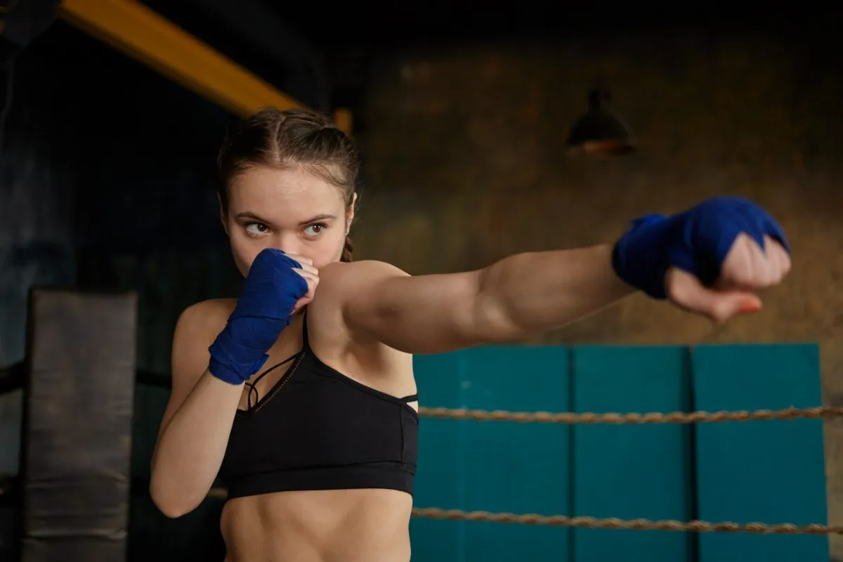 Jovem treinando golpe de Muay Thai com bandagens